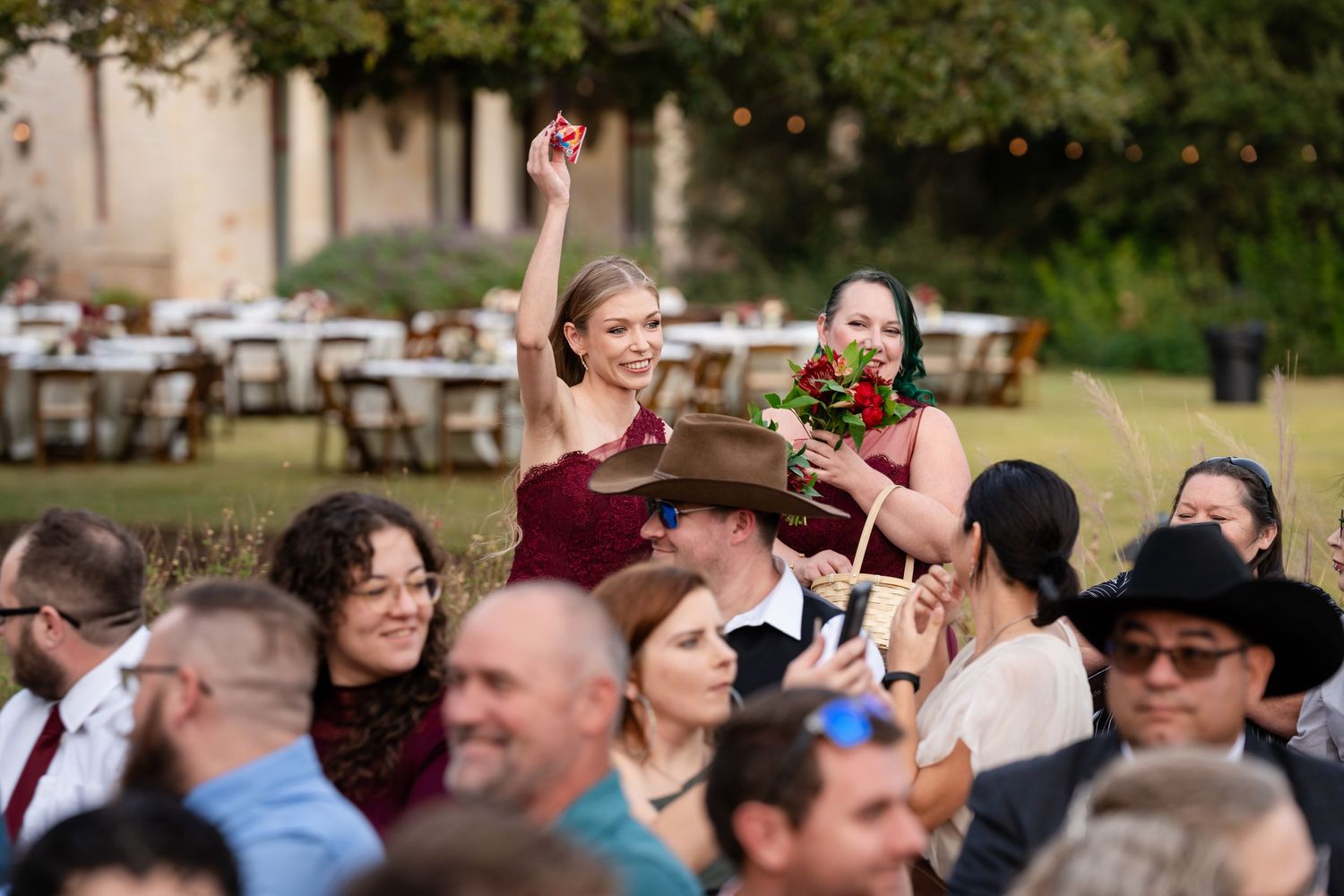 Wedding guests celebrate joyfully during outdoor reception with western theme.
