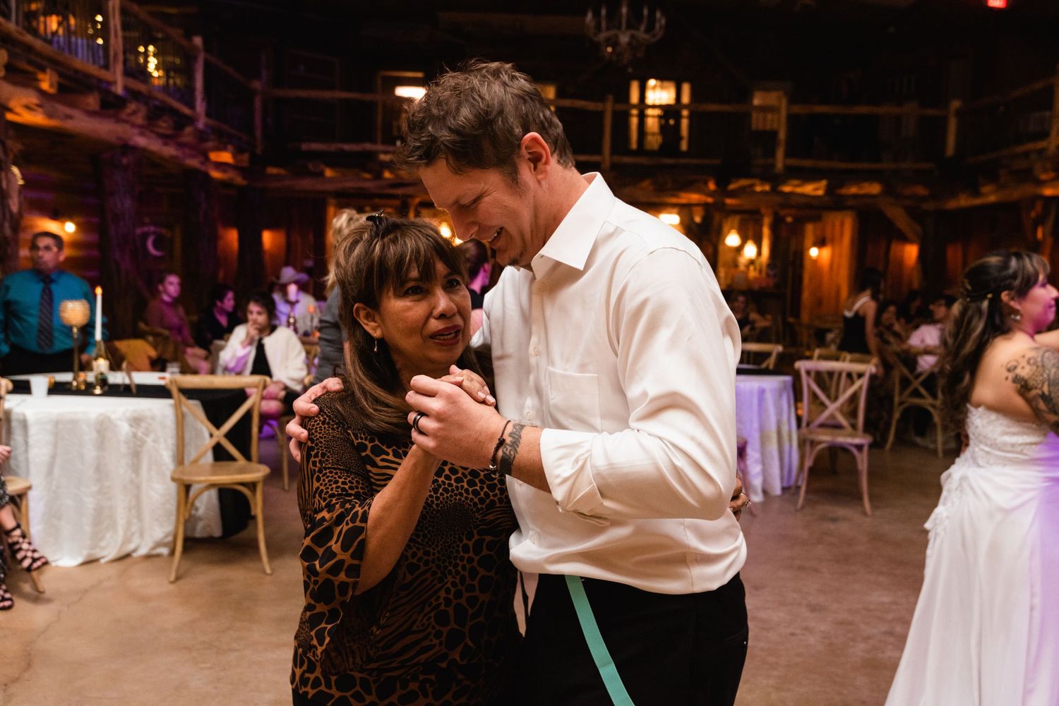 Guests sharing an intimate dance moment on the reception floor with warm lighting.