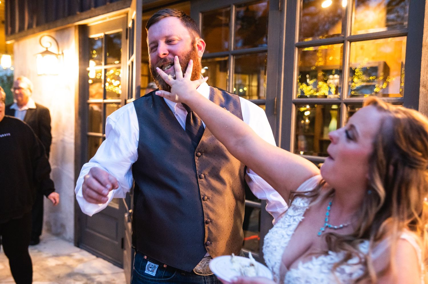Couple enjoys a fun cake-feeding moment at their wedding reception.