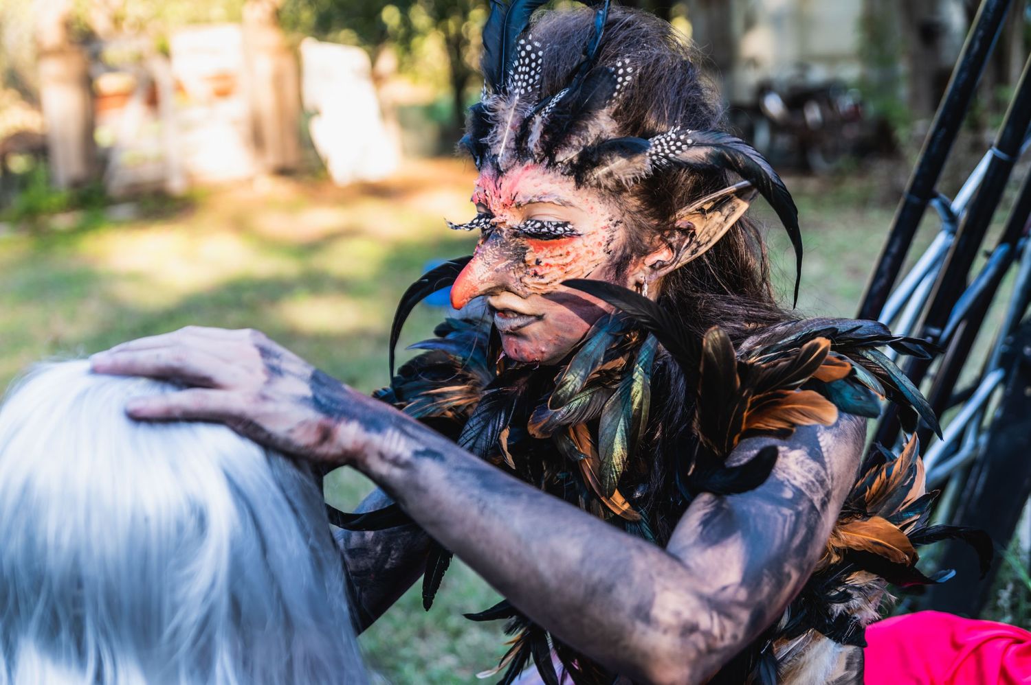 Detailed theatrical makeup and costume work being done outdoors.