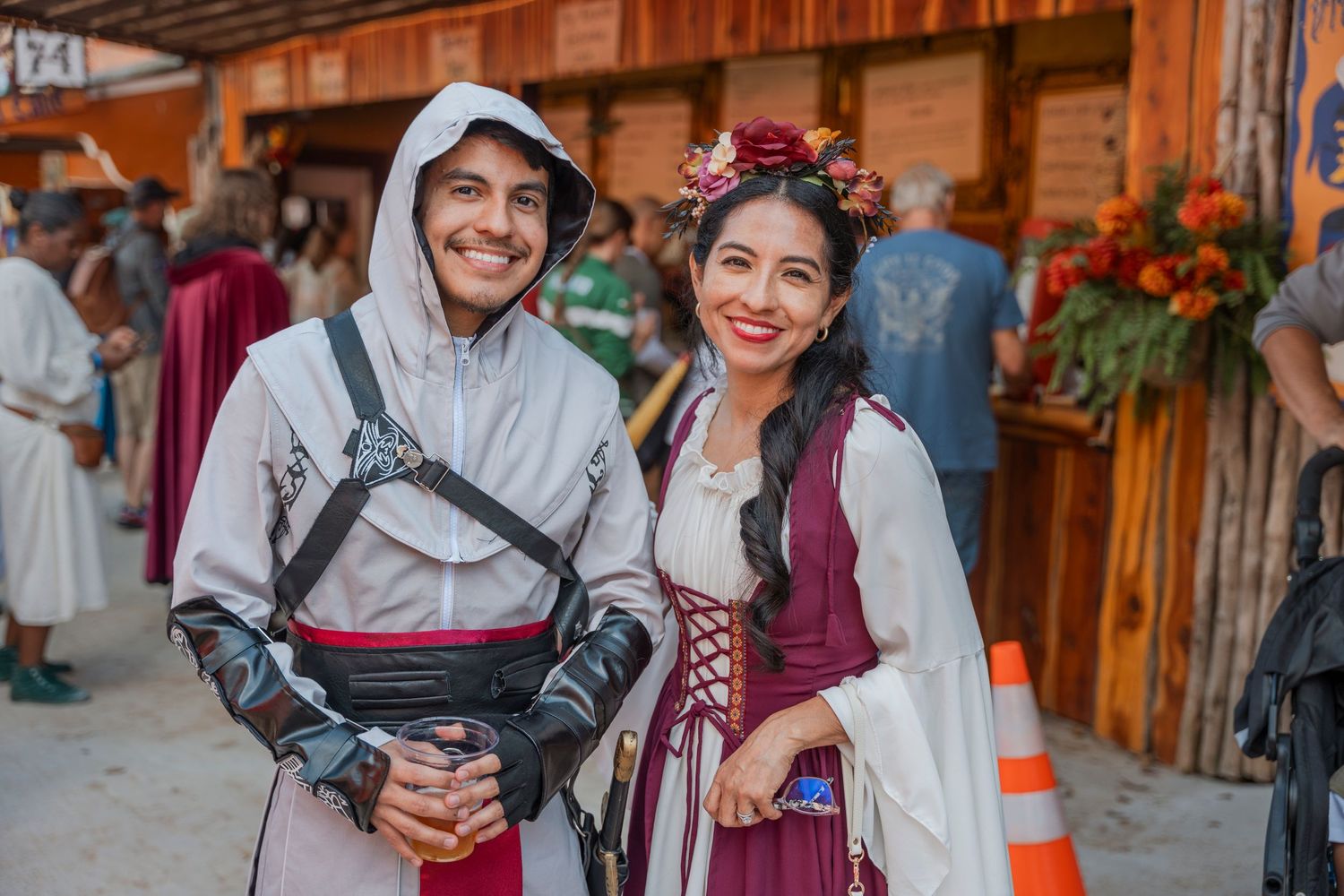 Festival attendees wearing medieval period costumes pose at a renaissance fair.