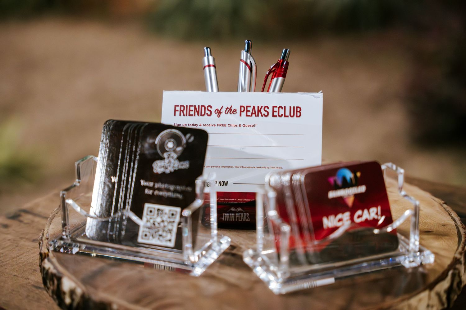 Marketing materials and business cards displayed on wooden surface for car club membership.
