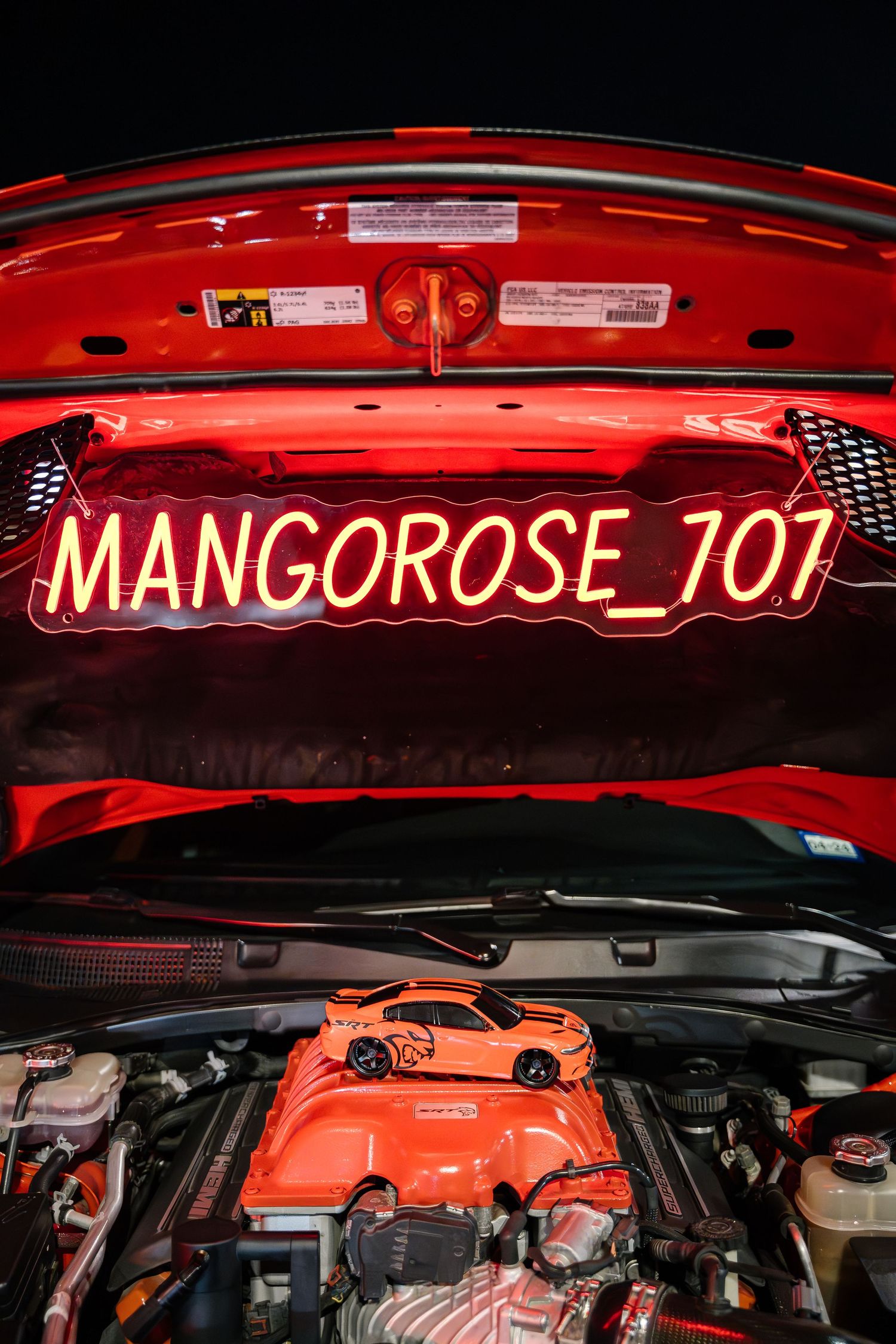 Red engine bay with illuminated Mangorose_707 custom LED sign visible under hood.