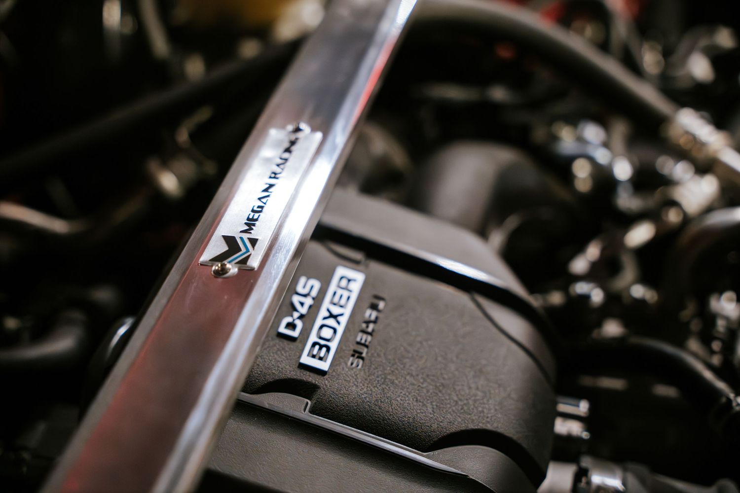 Close-up detail shot of a car engine bay showing performance parts and components.