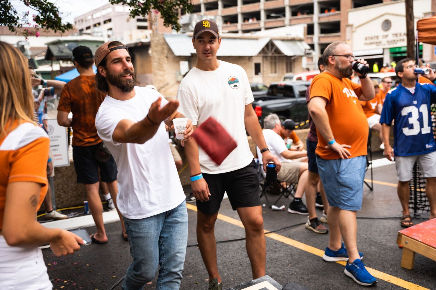 People enjoying casual outdoor tailgate party with games.