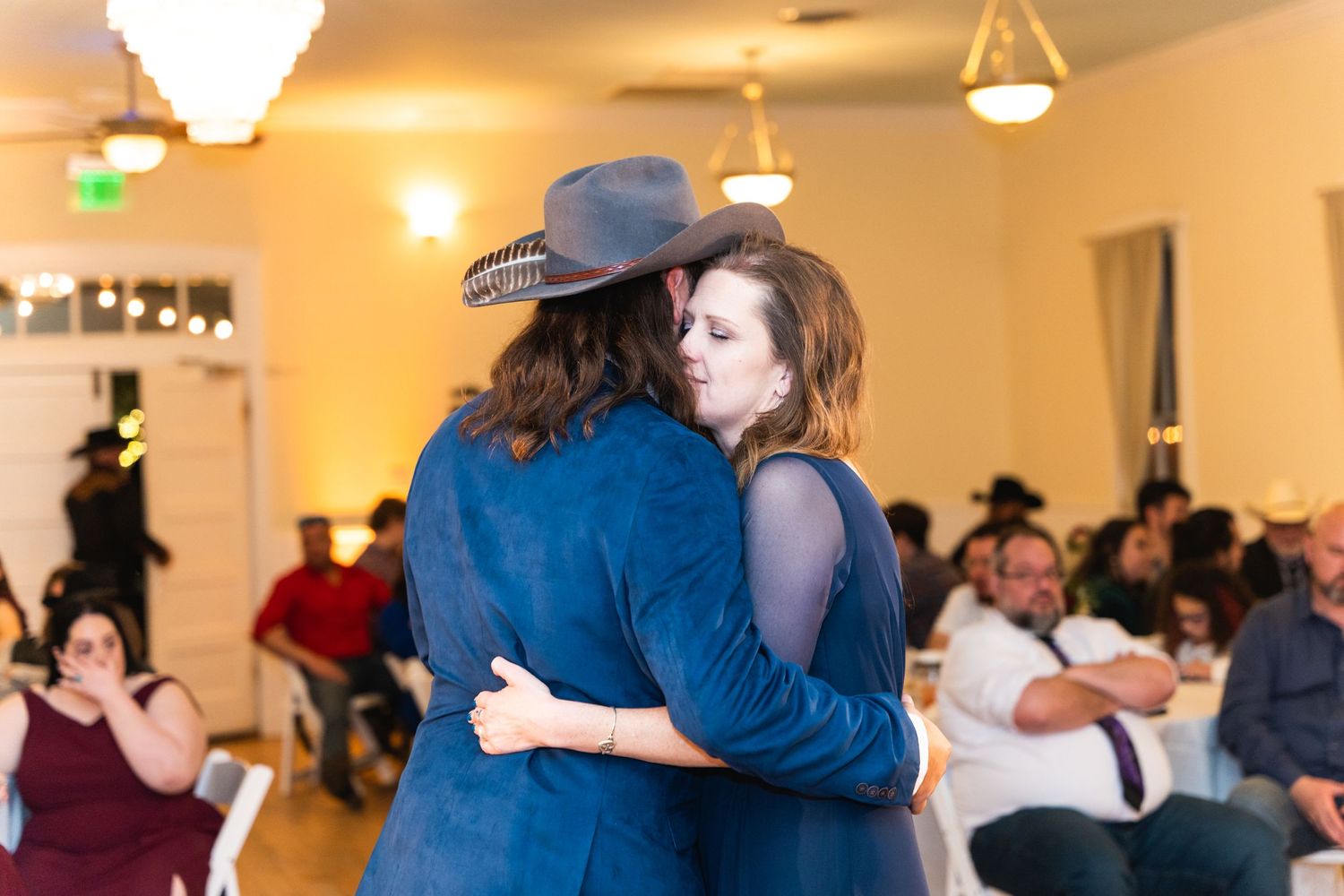 Guests sharing a dance during a country western themed wedding reception.