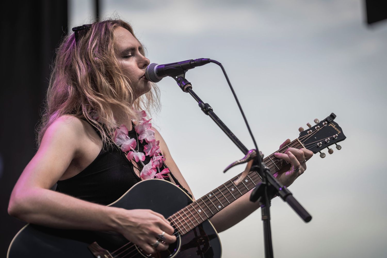 A musician performs on stage with an acoustic guitar during a live concert performance.