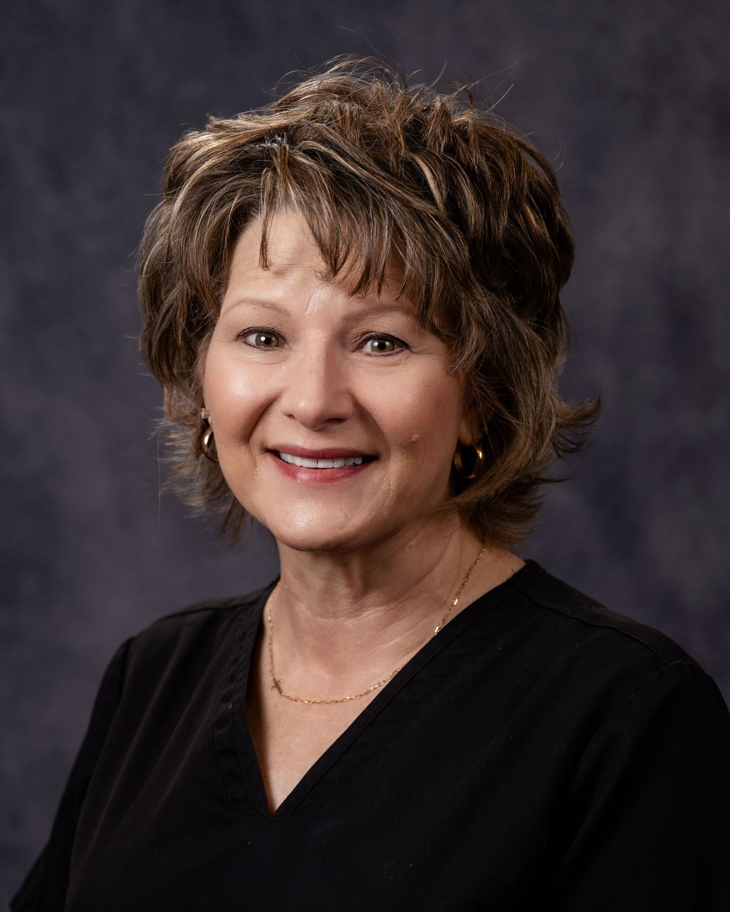 Professional headshot portrait of someone in black attire against dark background in multiple poses.