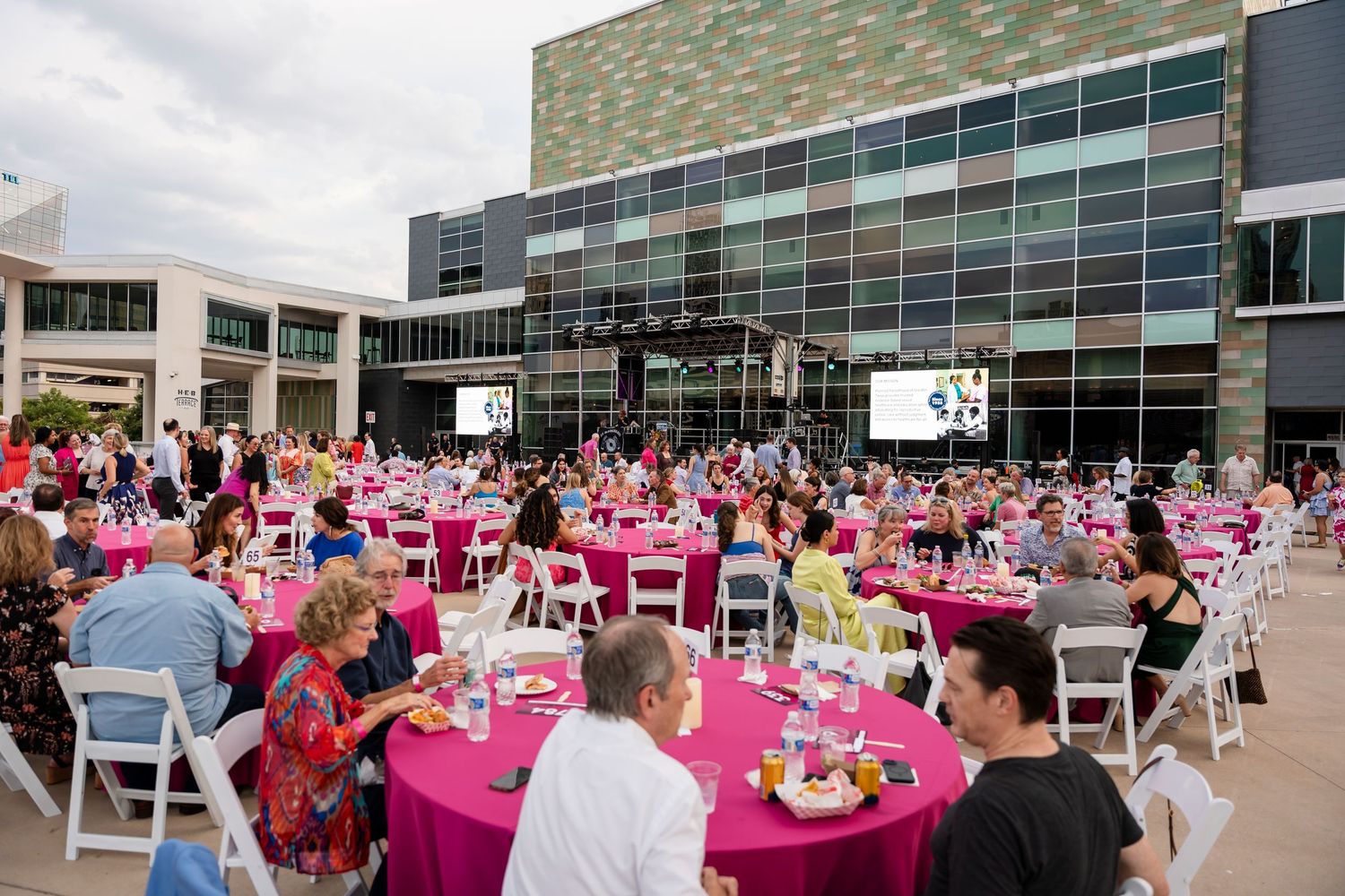 A large banquet hall set up with pink tablecloths and decorations for a formal event.