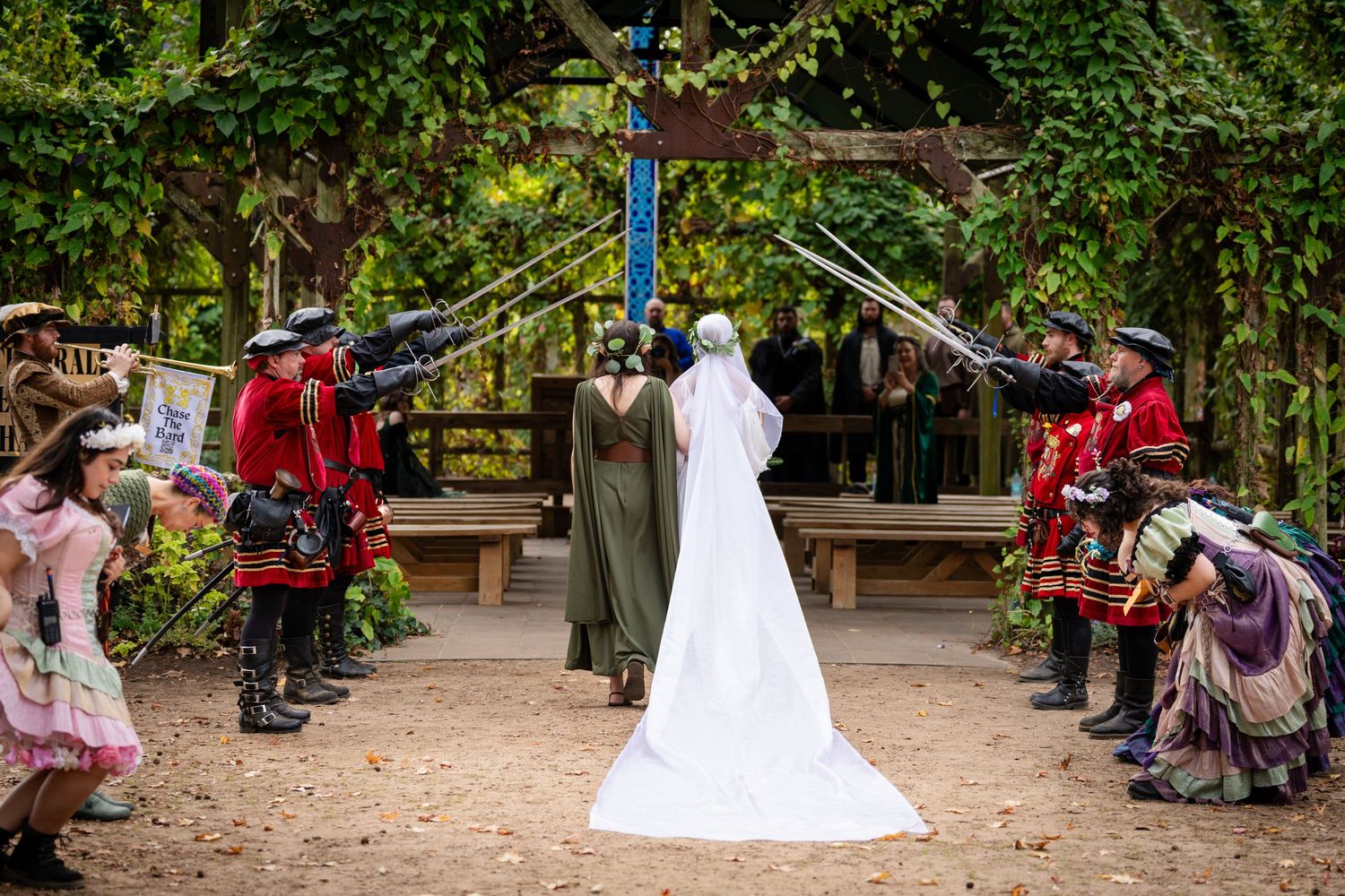 Wedding guests line a garden path to celebrate as newlyweds walk through a shower of bubbles during outdoor ceremony.