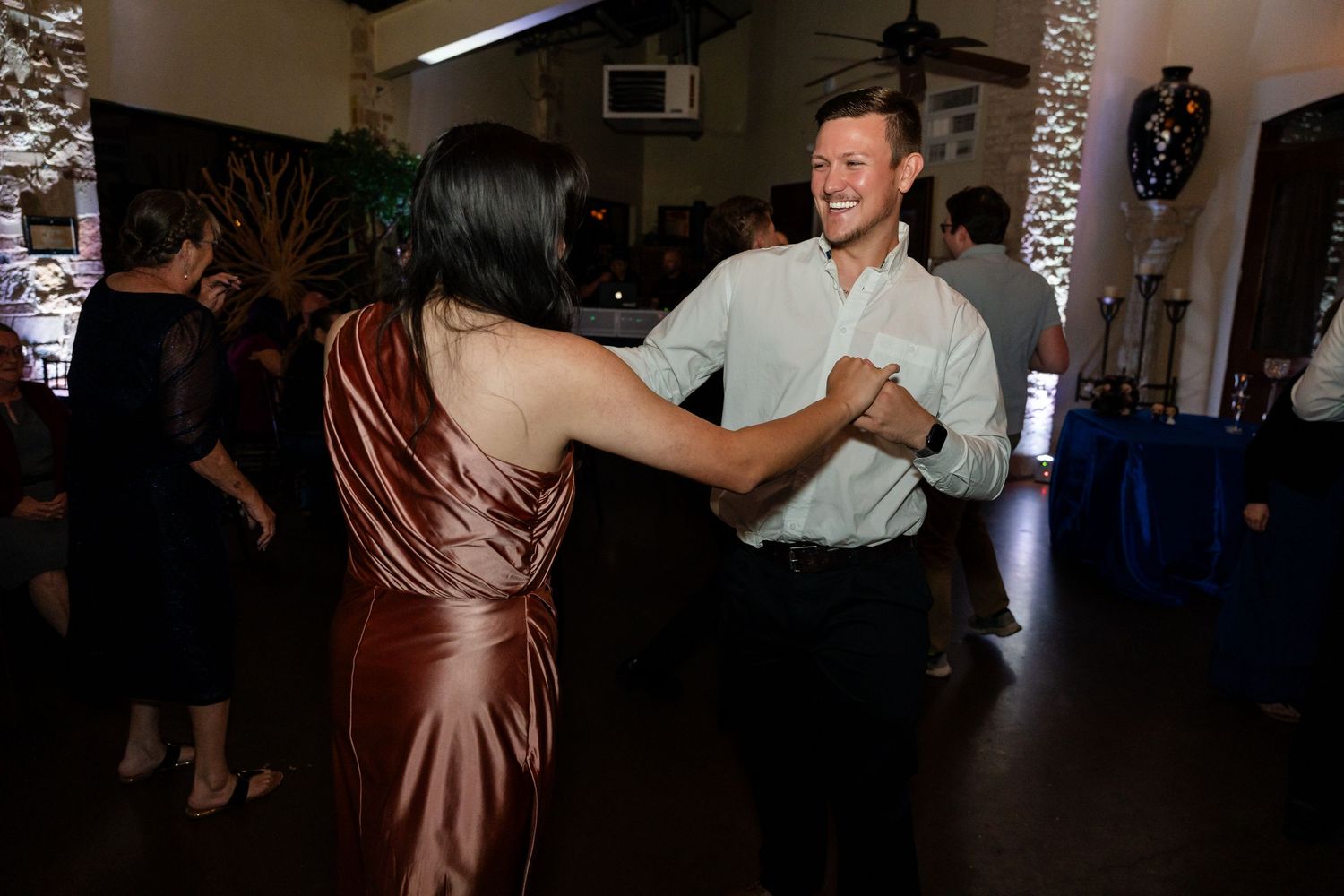 A pair of dancers swing together during an energetic dance at a reception venue.