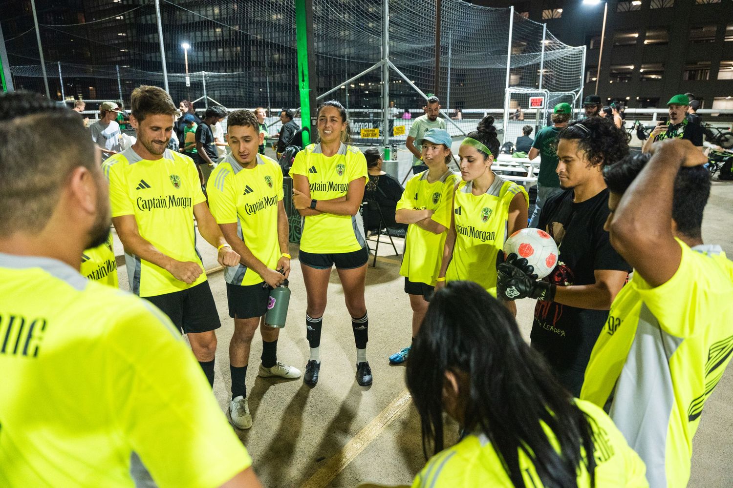 Team in neon yellow uniforms huddles together during a break in the game.