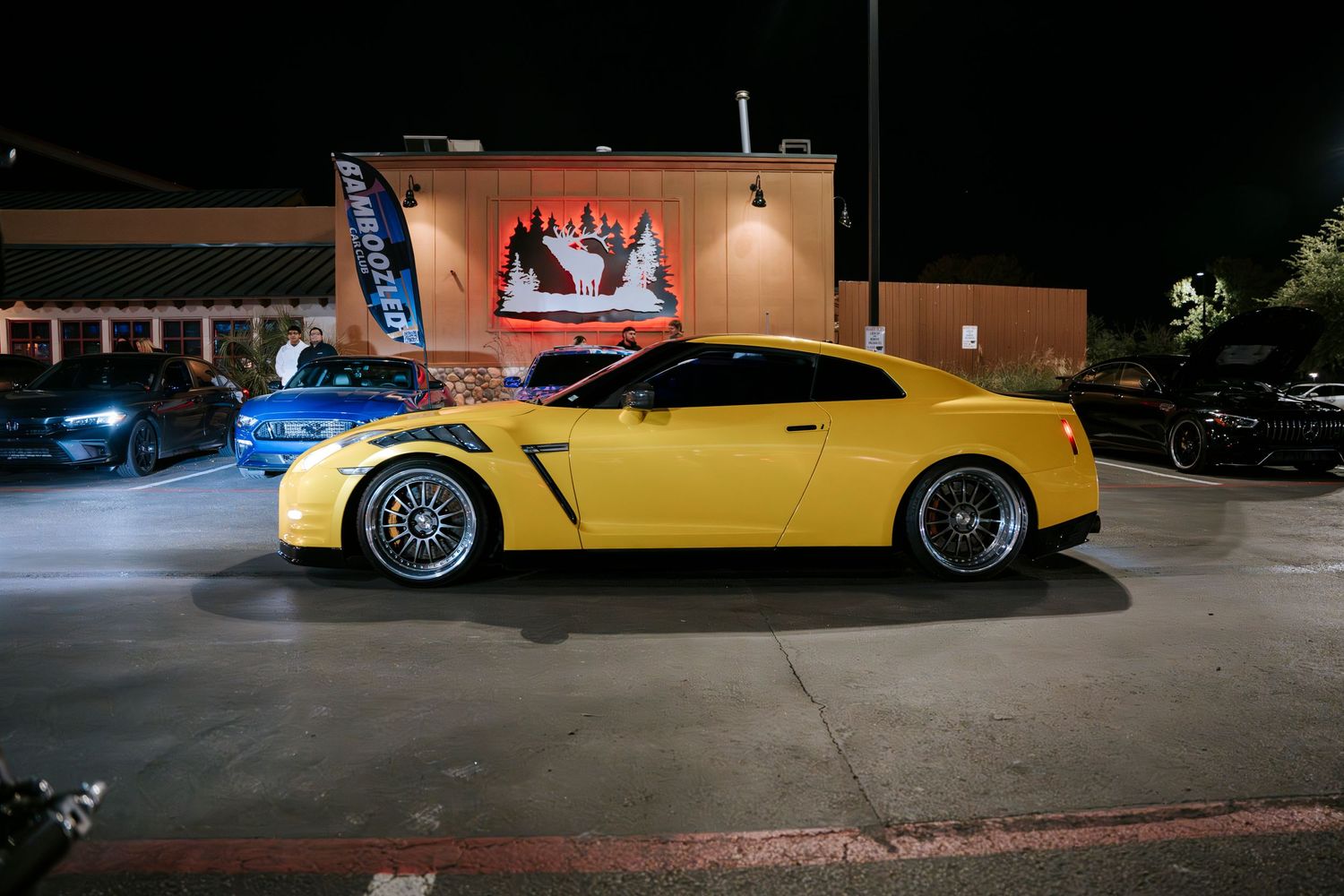 Yellow Nissan GT-R parked outside at night showing custom wheels.