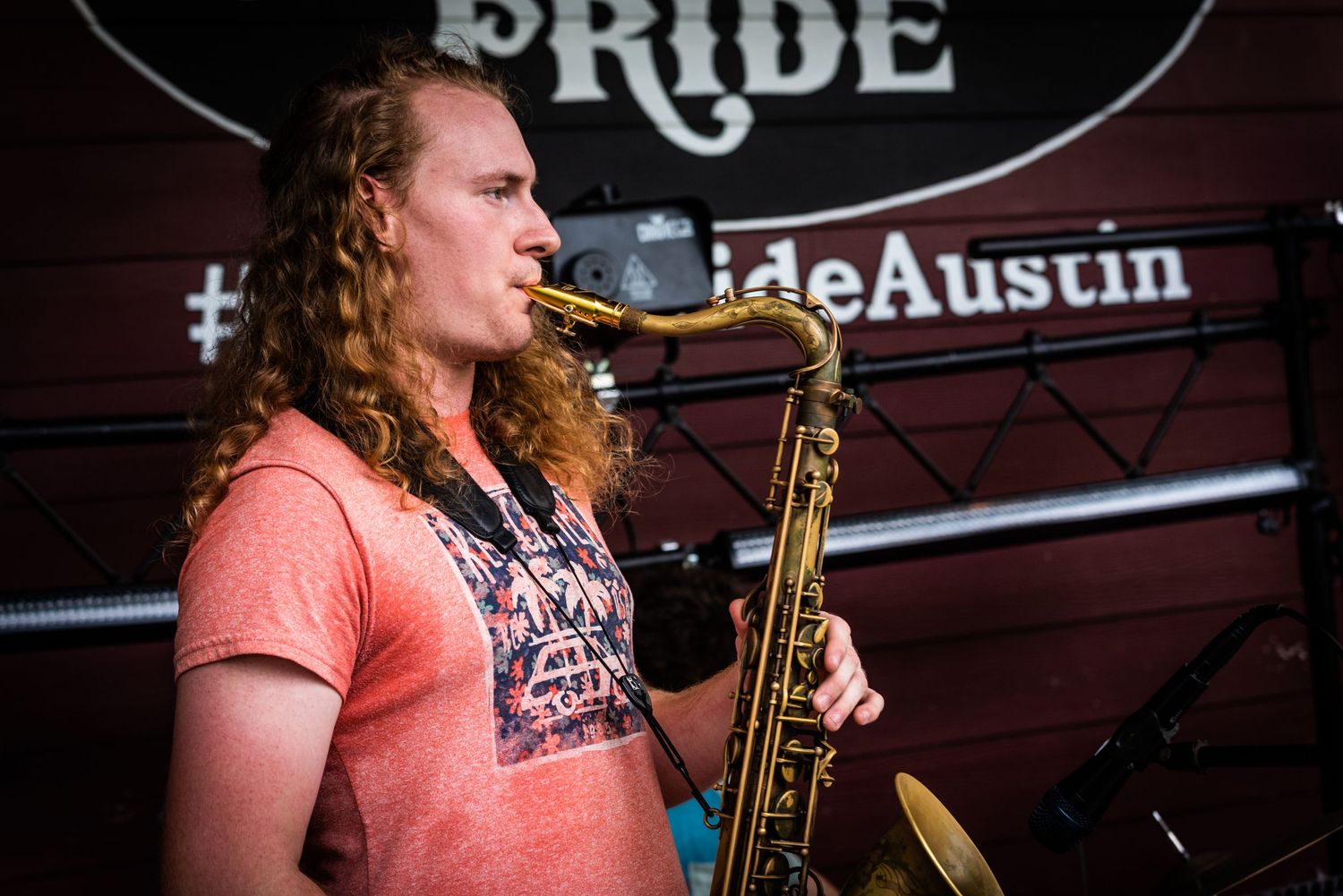 Musician performing with saxophone at Pride venue in Austin.