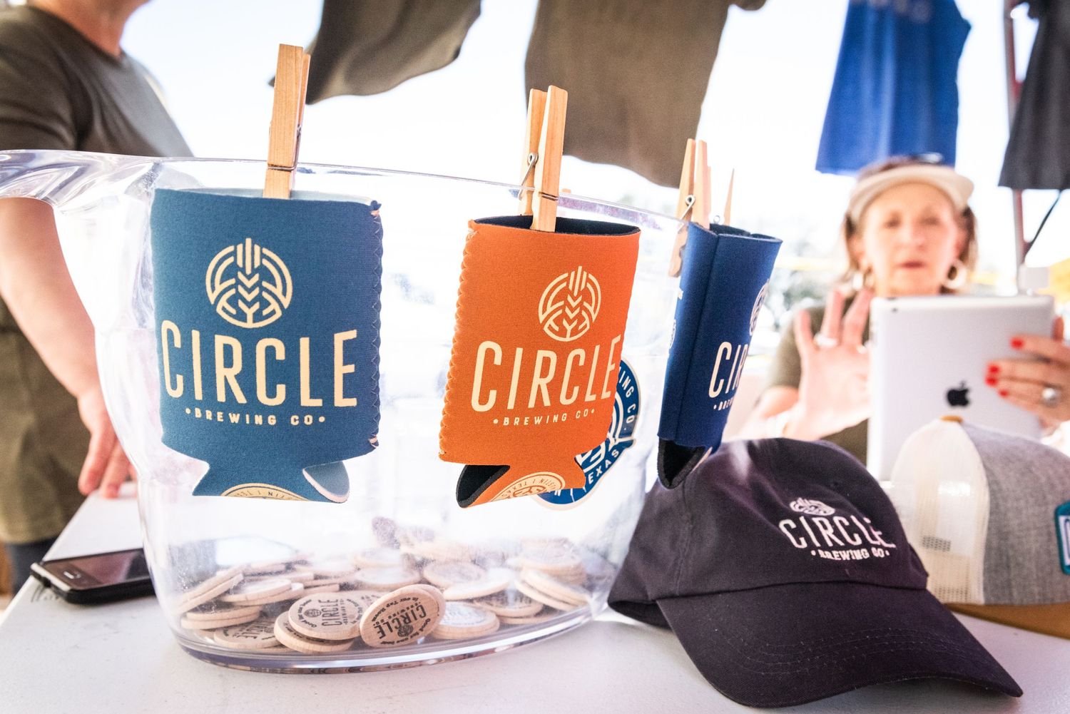Circle Brewing Company branded merchandise displayed on clothesline with koozies.