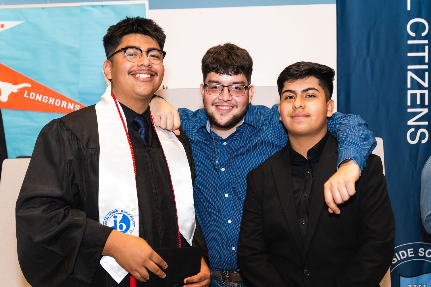 Three friends in graduation attire pose together for a celebratory photo.