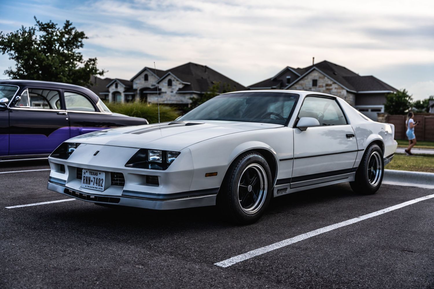 Classic white Chevrolet Camaro parked in lot with custom wheels and styling.
