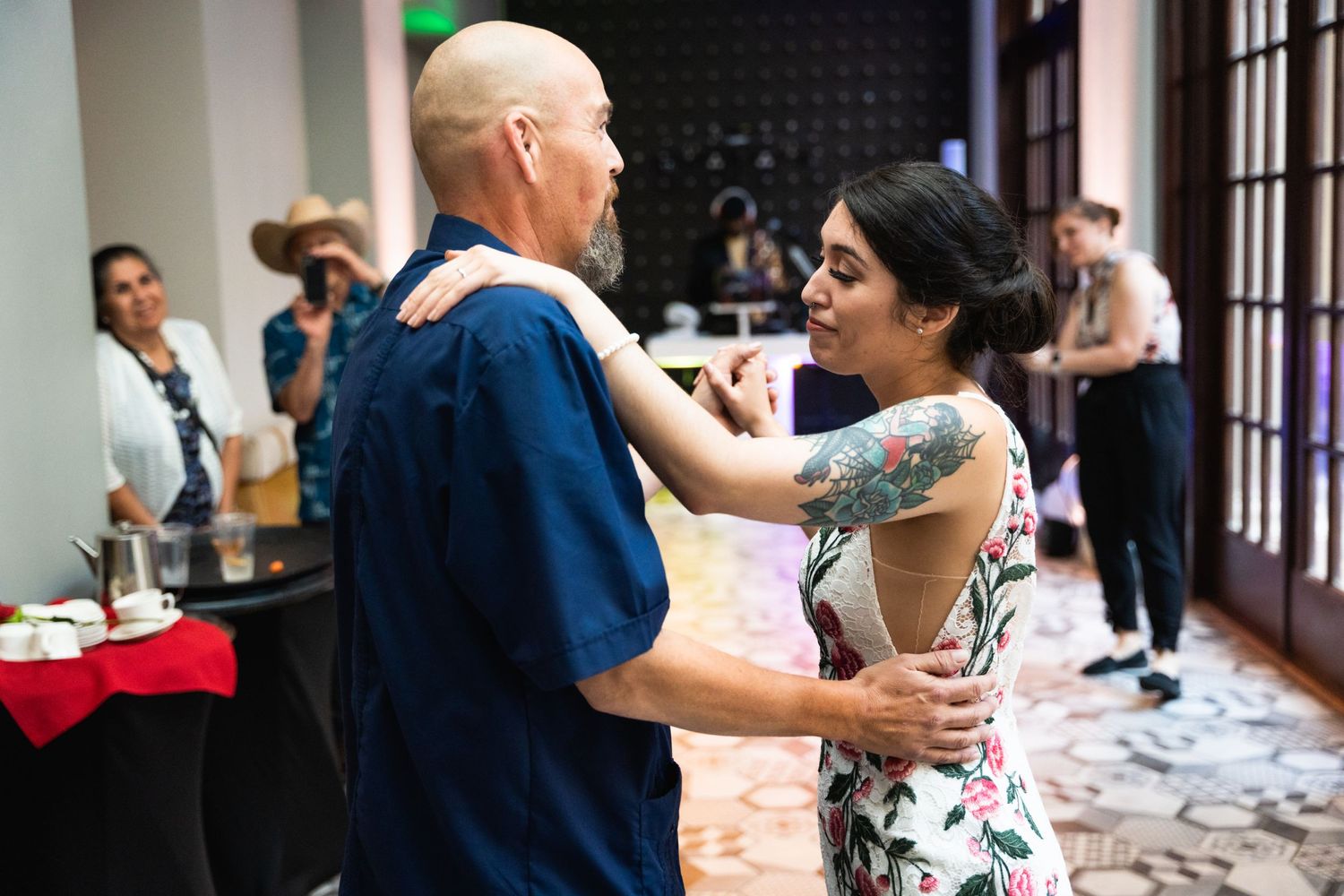 Couples dance together during a celebration in an elegant indoor venue.