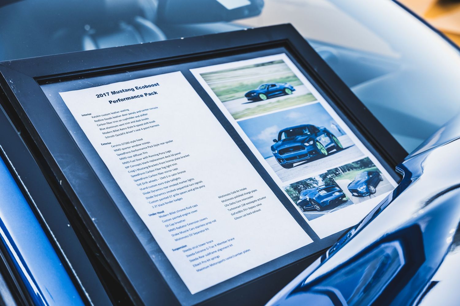 Vehicle specification sheet and photos displayed on digital tablet during car inspection.