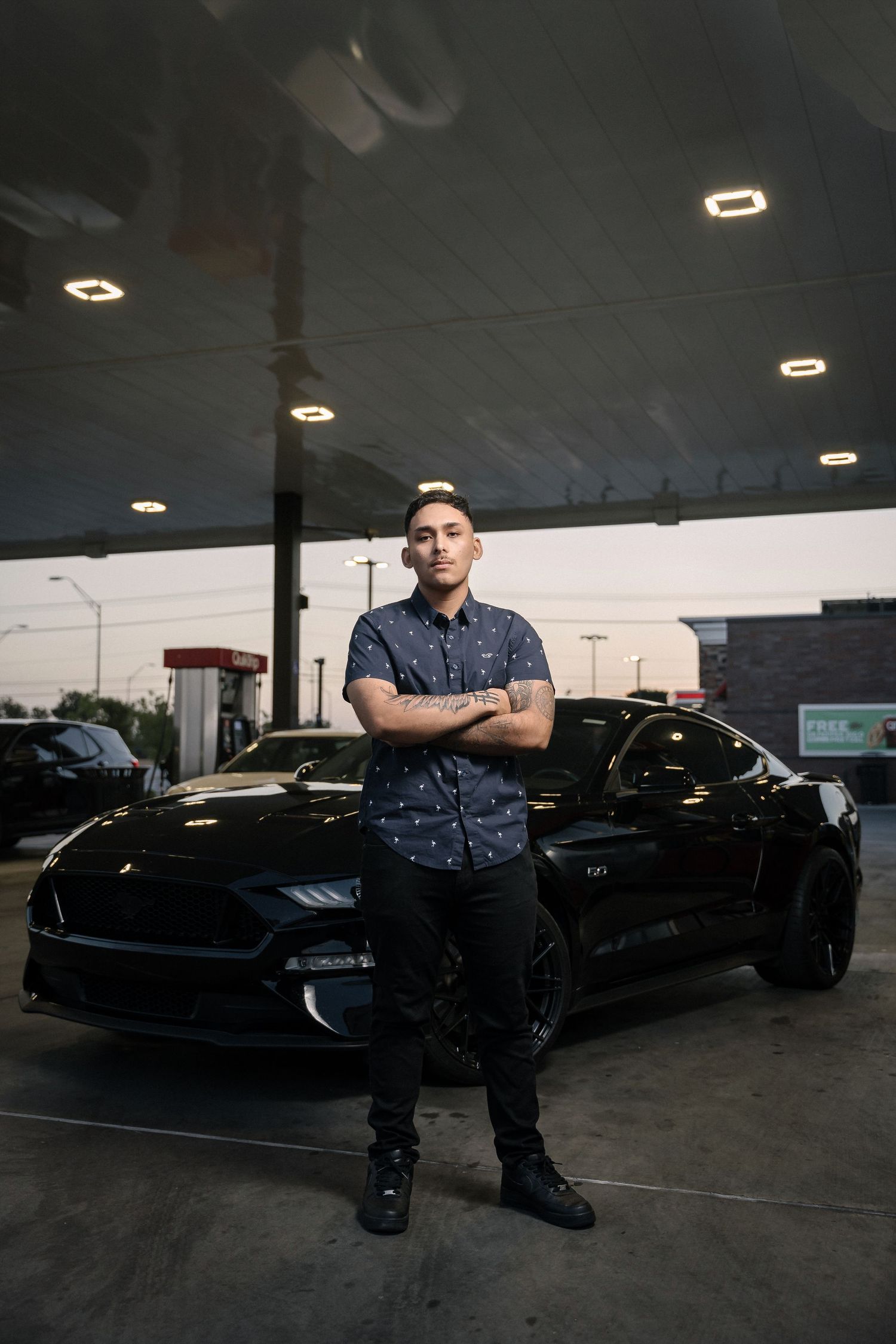 Casual portrait with black Mustang in underground parking garage.