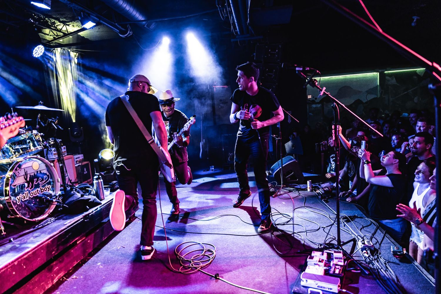 Band performs on elevated stage with blue spotlights and dramatic lighting effects.