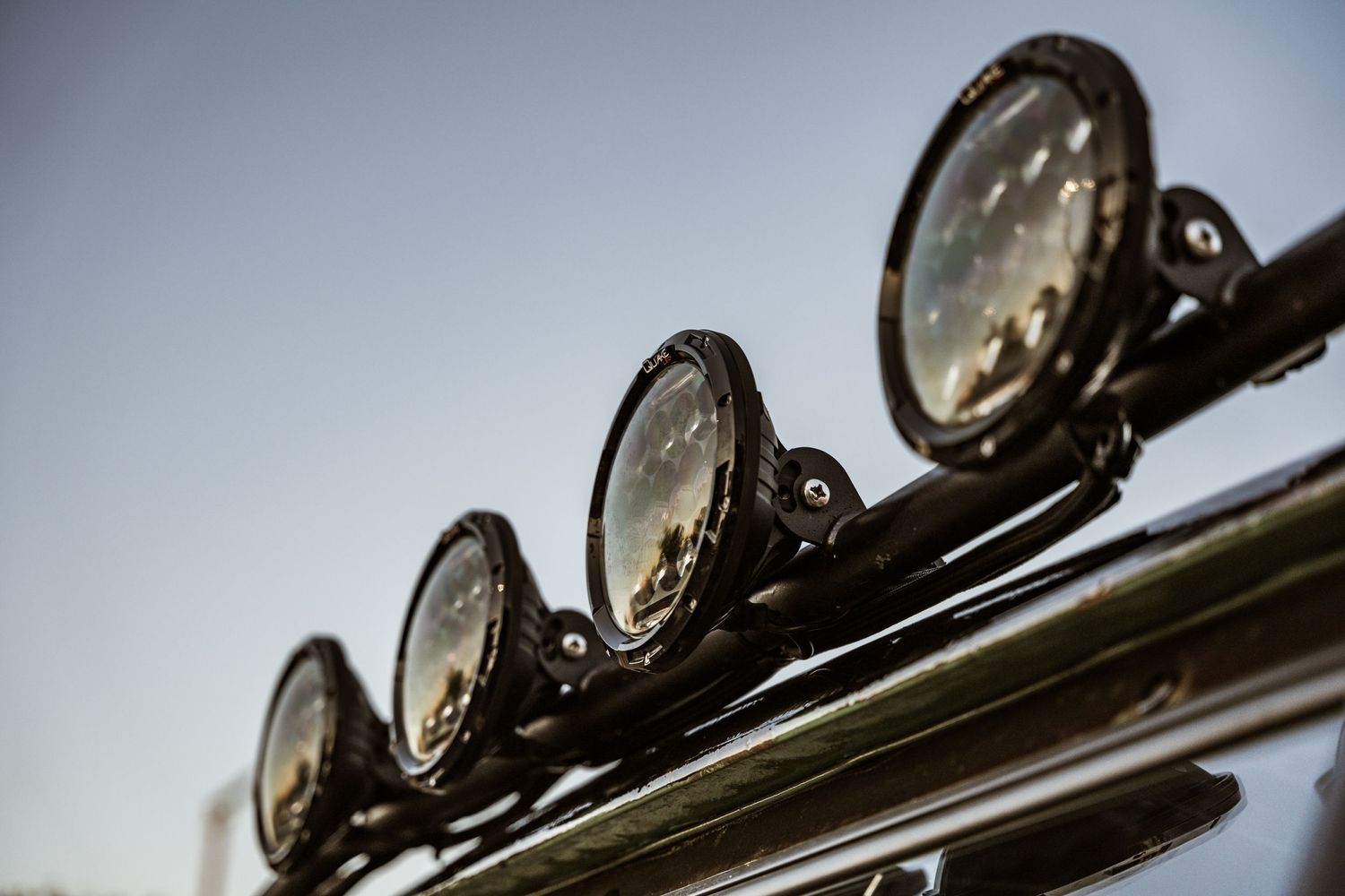 Close-up detail shot of vintage off-road spotlights mounted in a row.