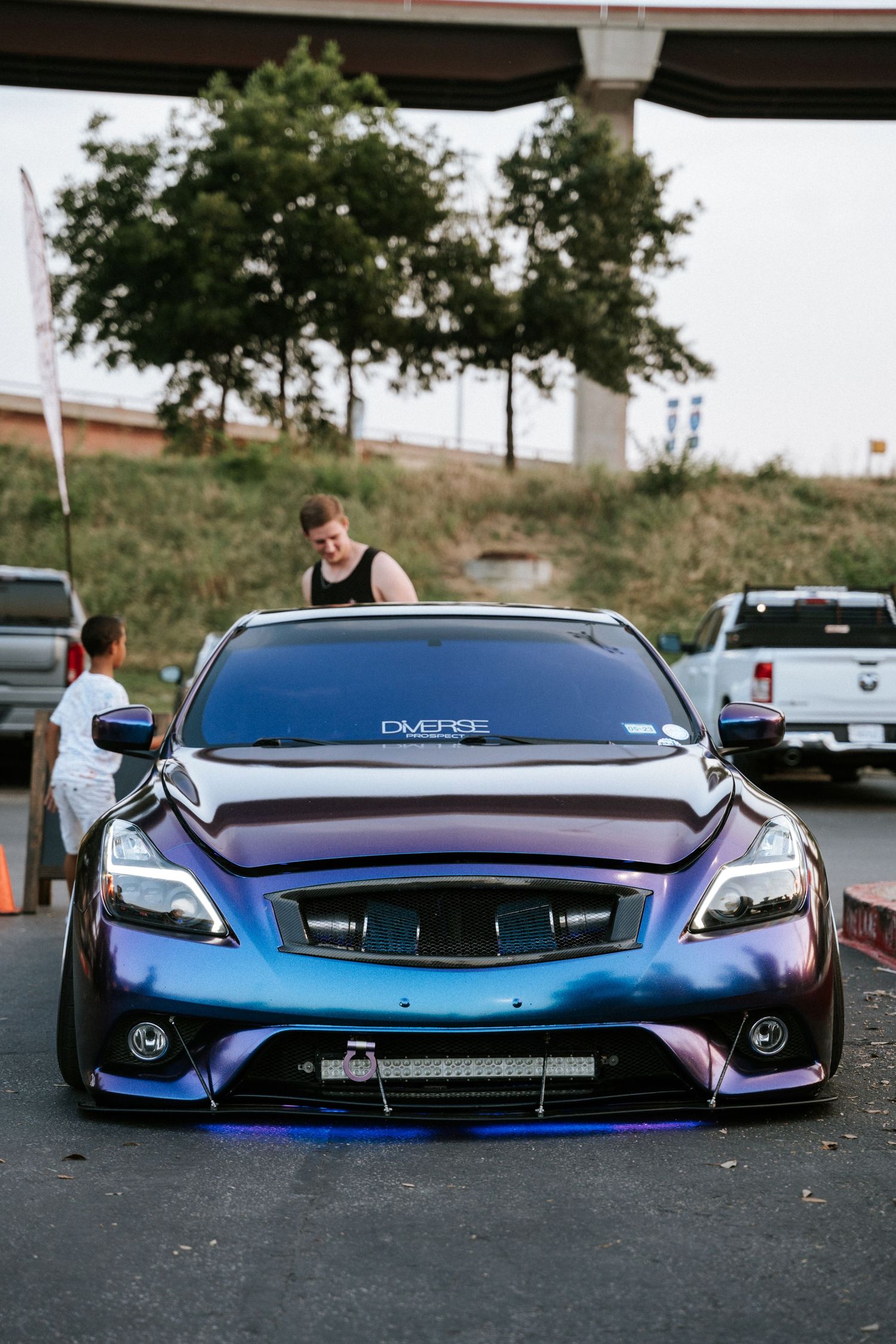 Modified blue Infiniti G37 with aggressive body kit and custom lighting.