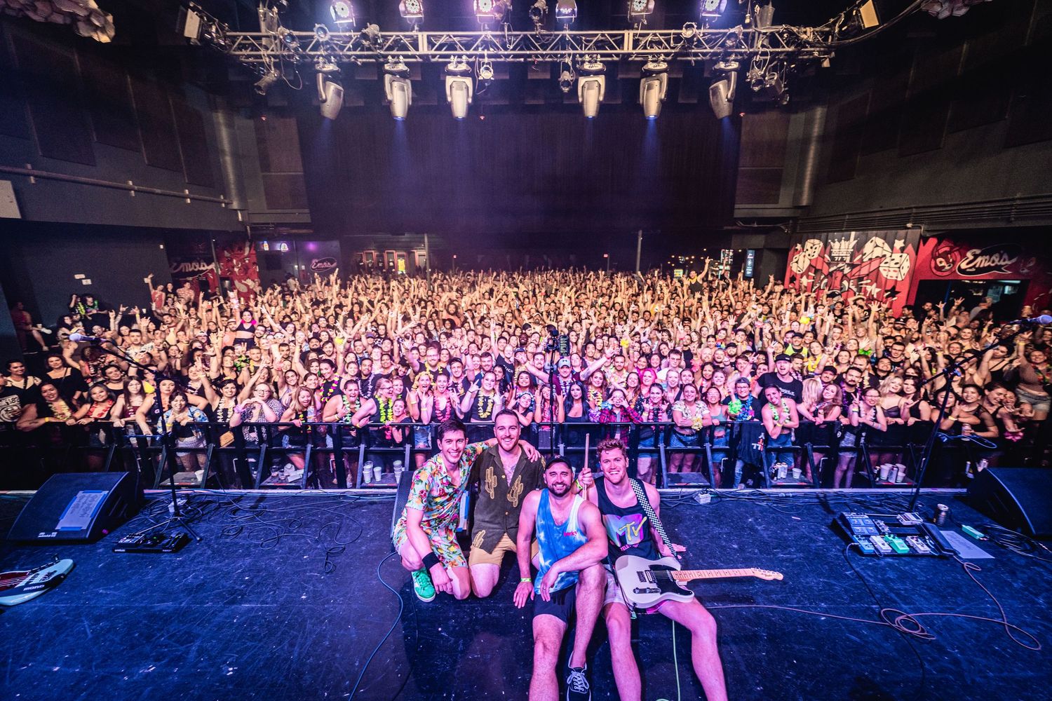 Concert crowd photographed from stage perspective with dramatic lighting and packed audience.