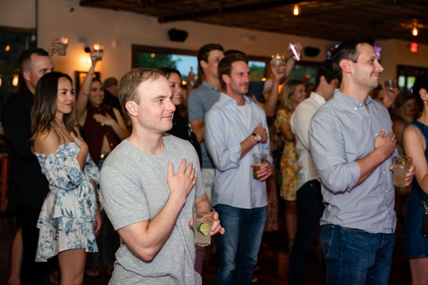 Crowd of people enjoying a lively indoor event with drinks.
