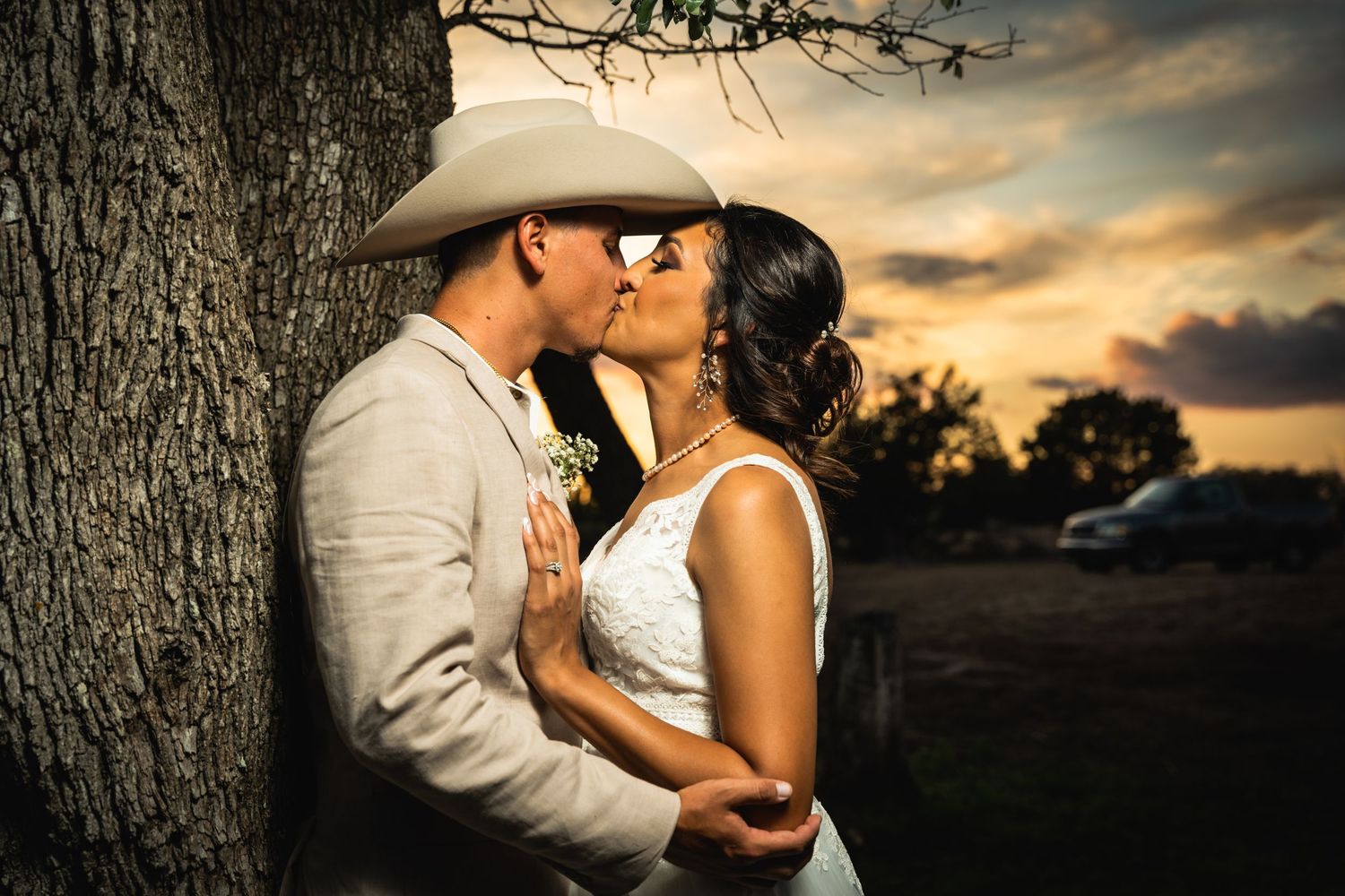 Romantic sunset portrait against a tree trunk in western attire.