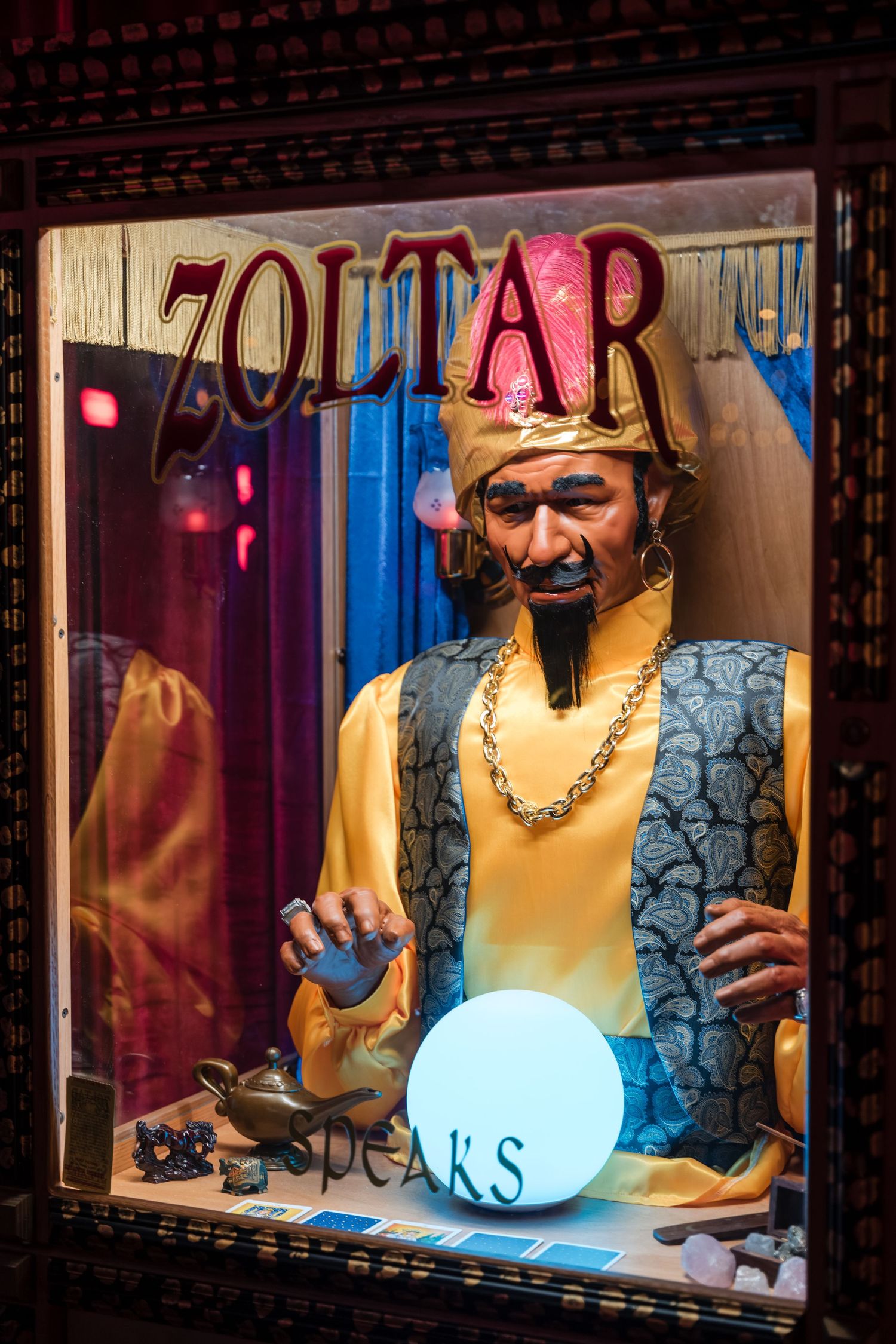 A series of photos showing someone performing with a glowing blue orb in a dimly lit venue with red lighting.