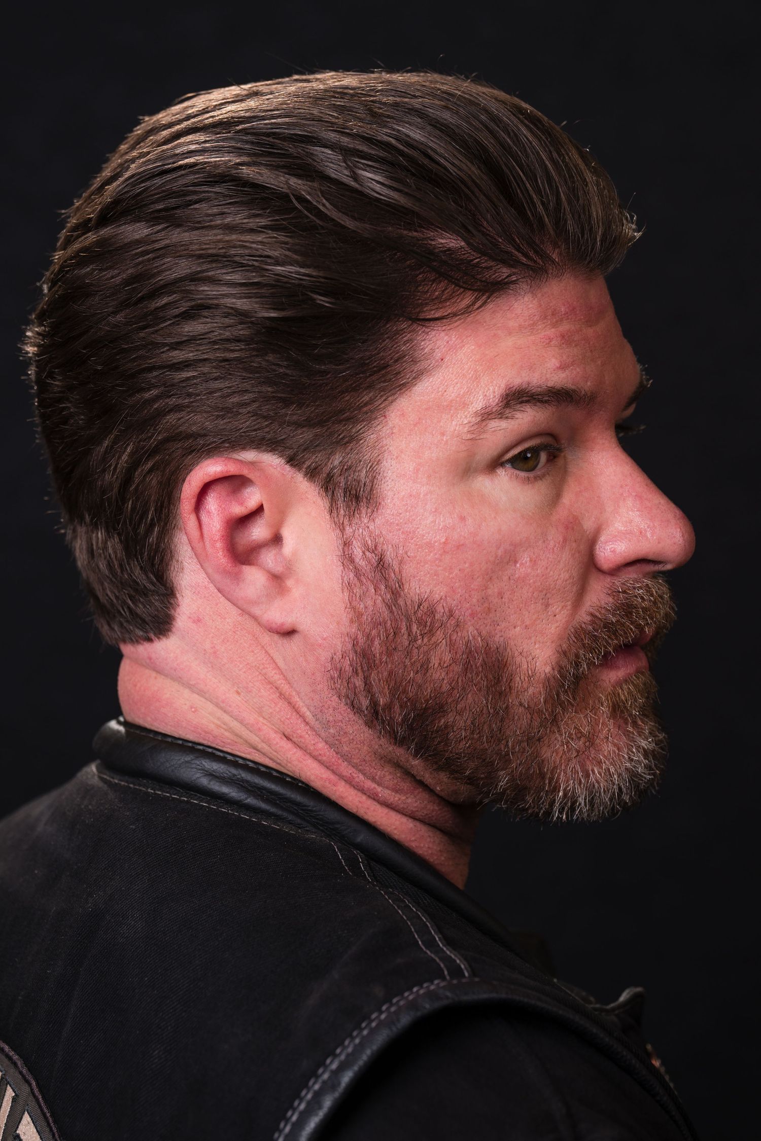 Profile view portraits showing facial hair and dark clothing against black background from multiple angles.