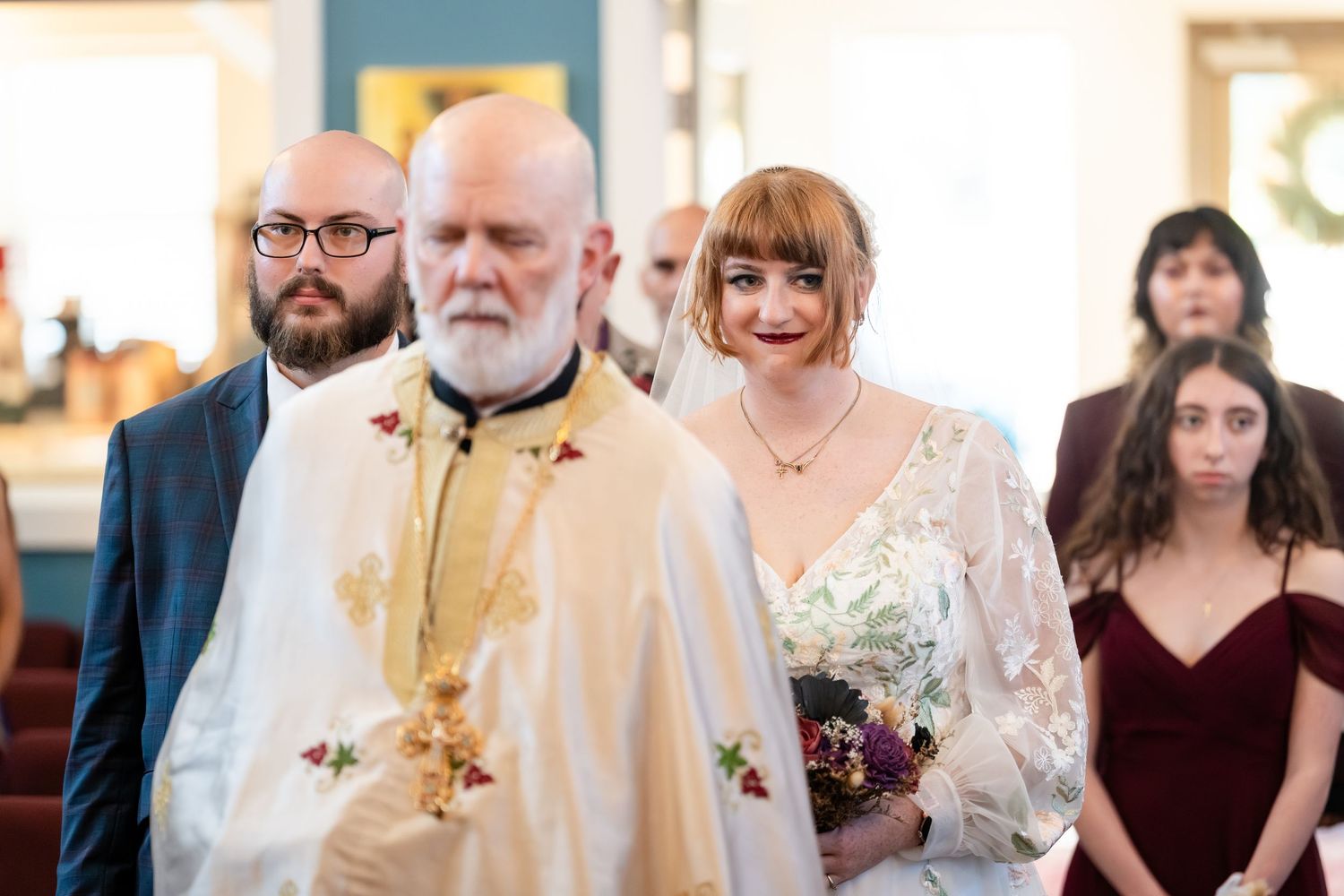 A group of people gather in formal attire at what appears to be a wedding ceremony or religious event.