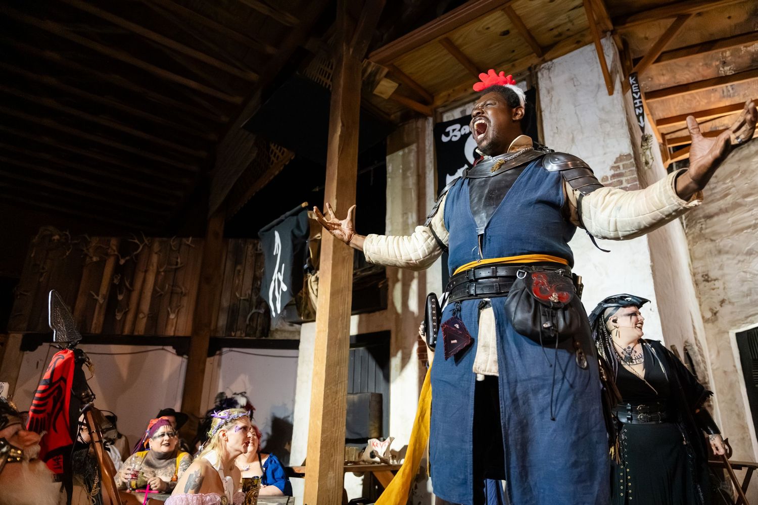 Vintage clothing and memorabilia displayed in a rustic wooden room with overalls, hats, and tools on the walls.