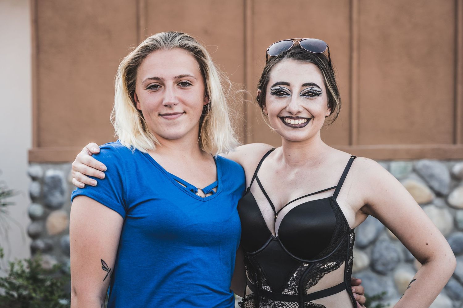 Two young women posing together at an outdoor event.