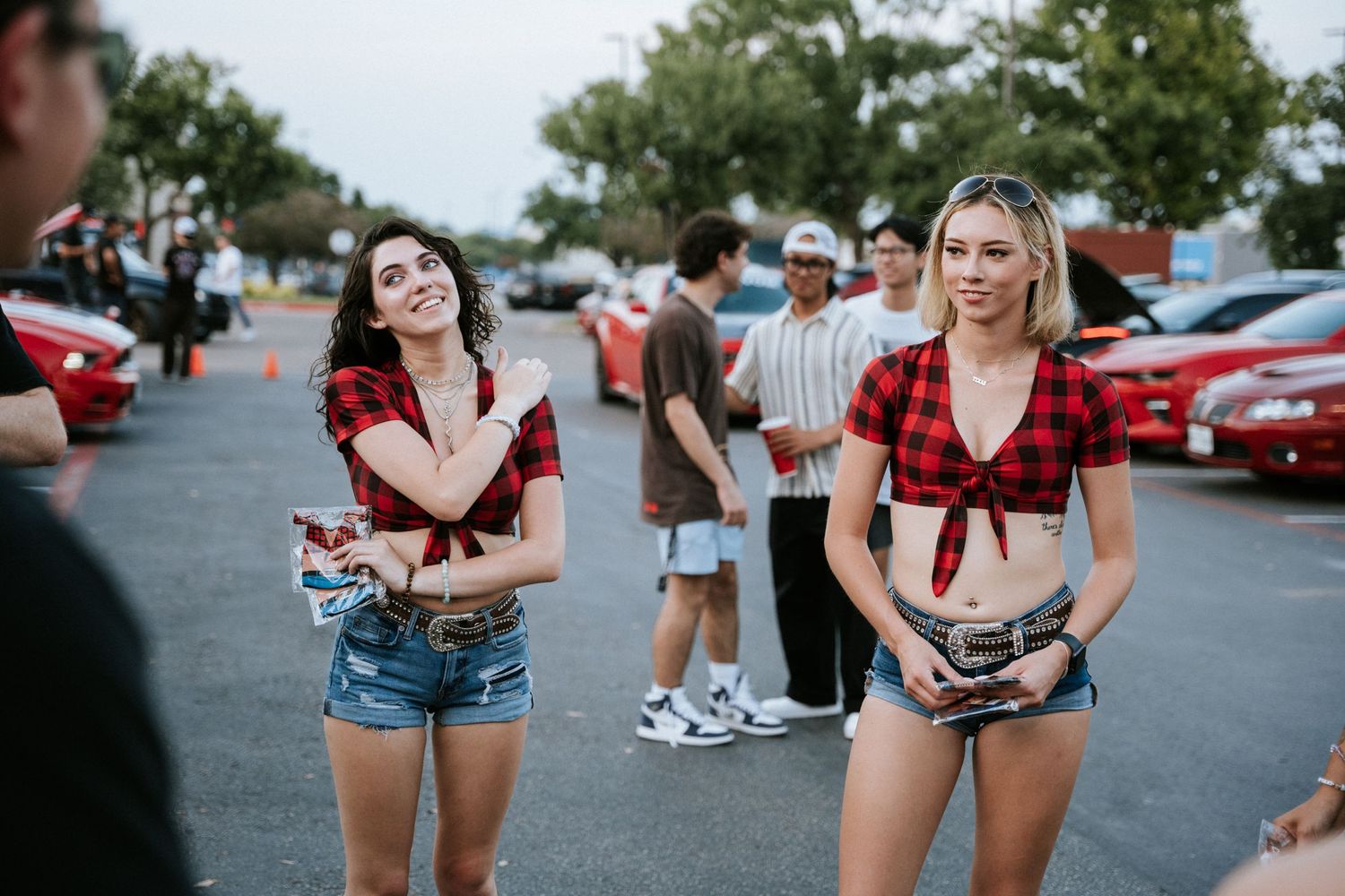 Friends enjoying a casual outdoor gathering in a parking lot.
