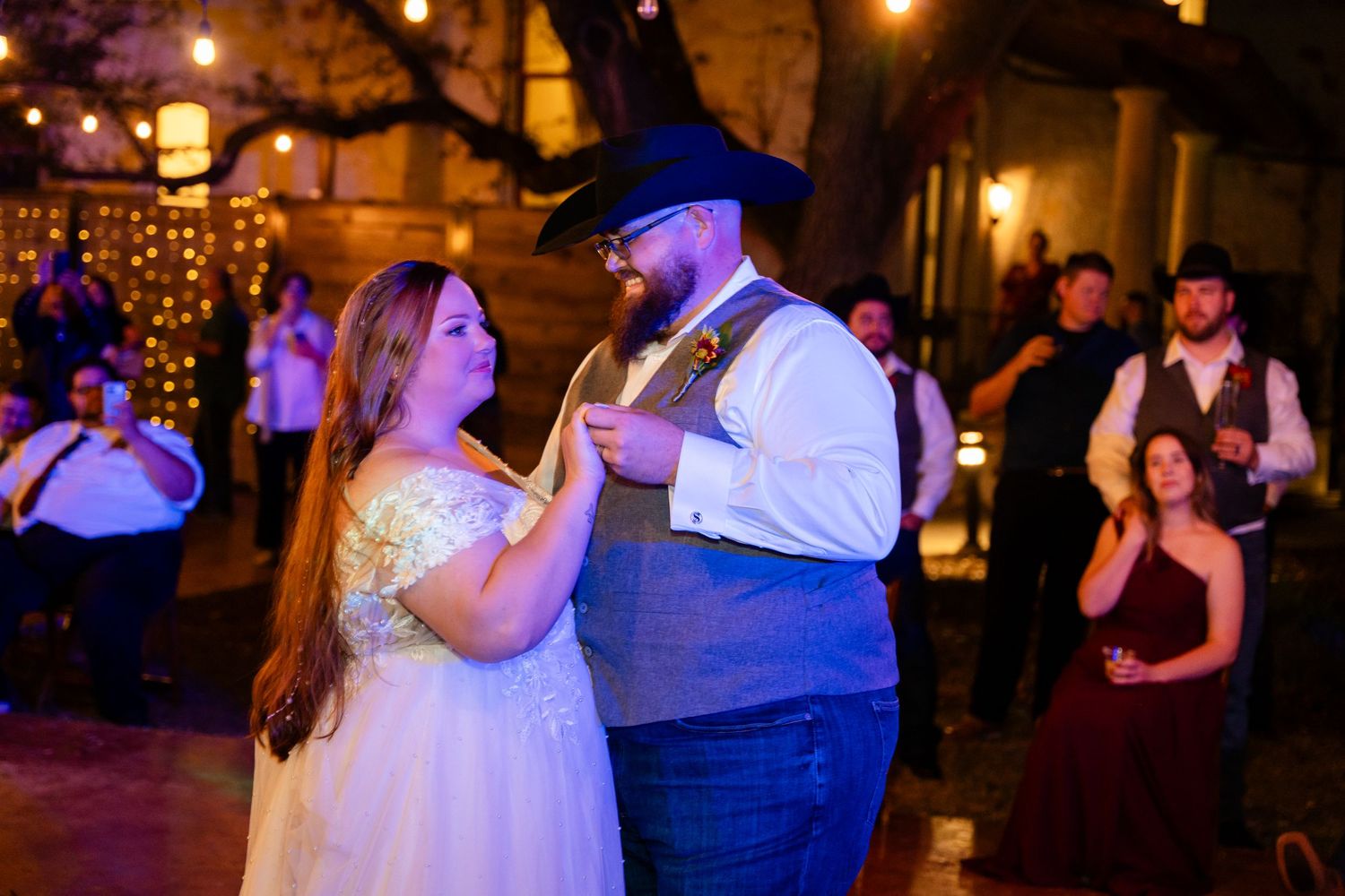 Couple sharing romantic dance moment at dimly lit wedding reception.
