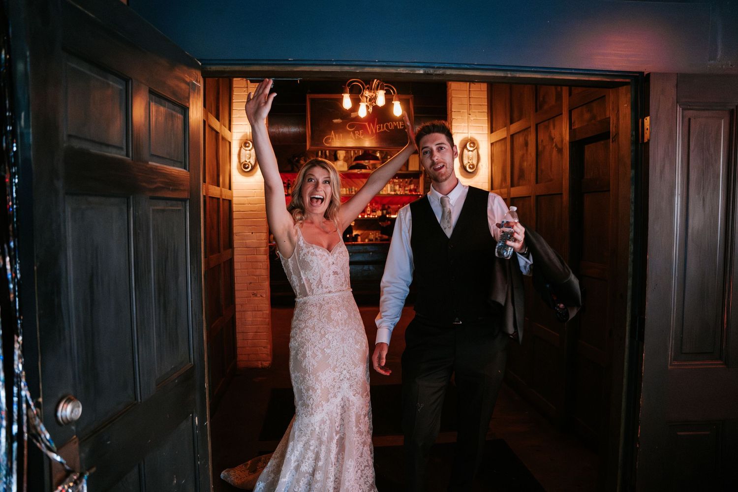 Celebratory moment captured in a rustic wood-paneled venue with warm lighting.