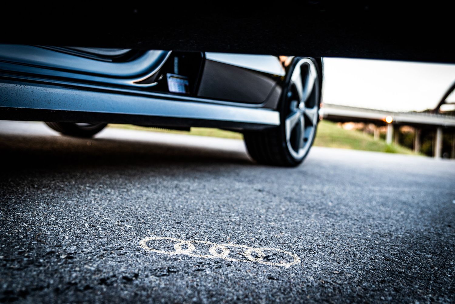 Low angle detail shot of Audi wheel and side skirt against asphalt surface.
