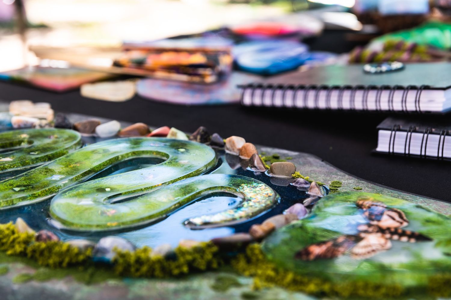 Close-up detail of a decorative artwork showing textured green elements and metallic accents.