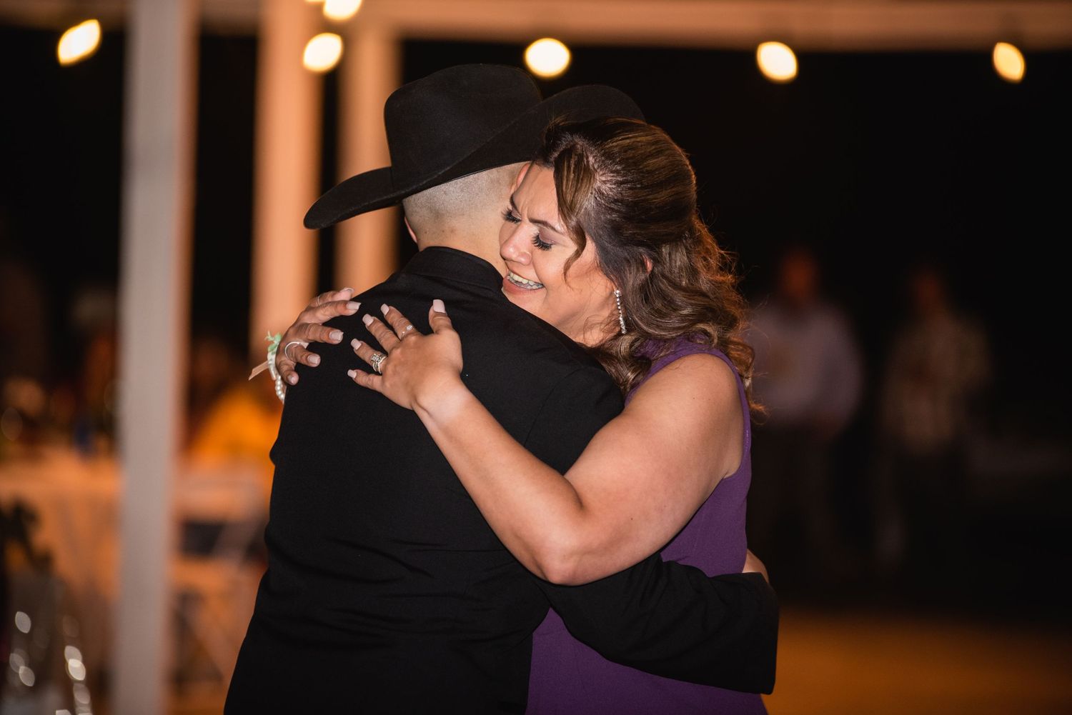 An emotional dance moment captured between two people during evening wedding reception.
