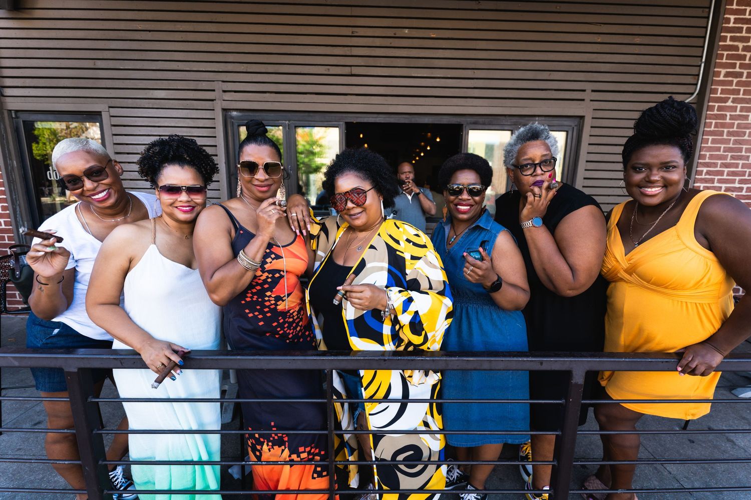 Group of friends pose together on a balcony during a summer party celebration.