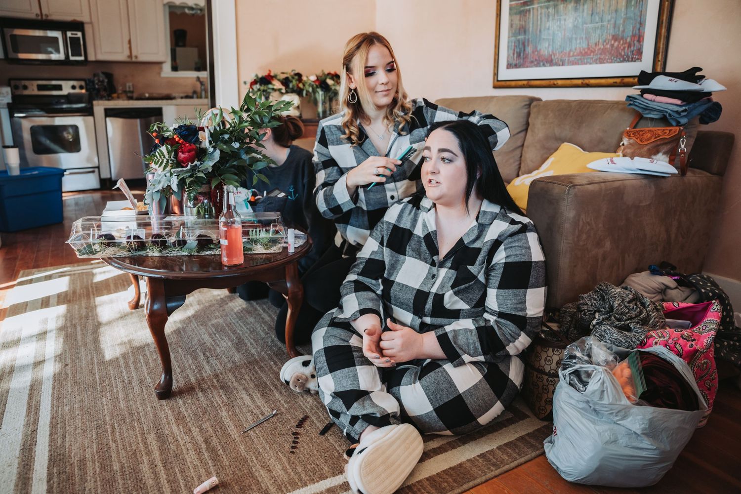 Wedding day preparation scene in cozy home setting with makeup artist at work.