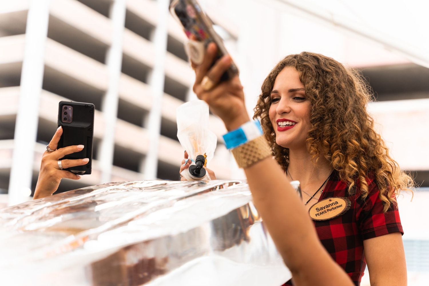 Server pours beverages at an outdoor event with parking structure in background.