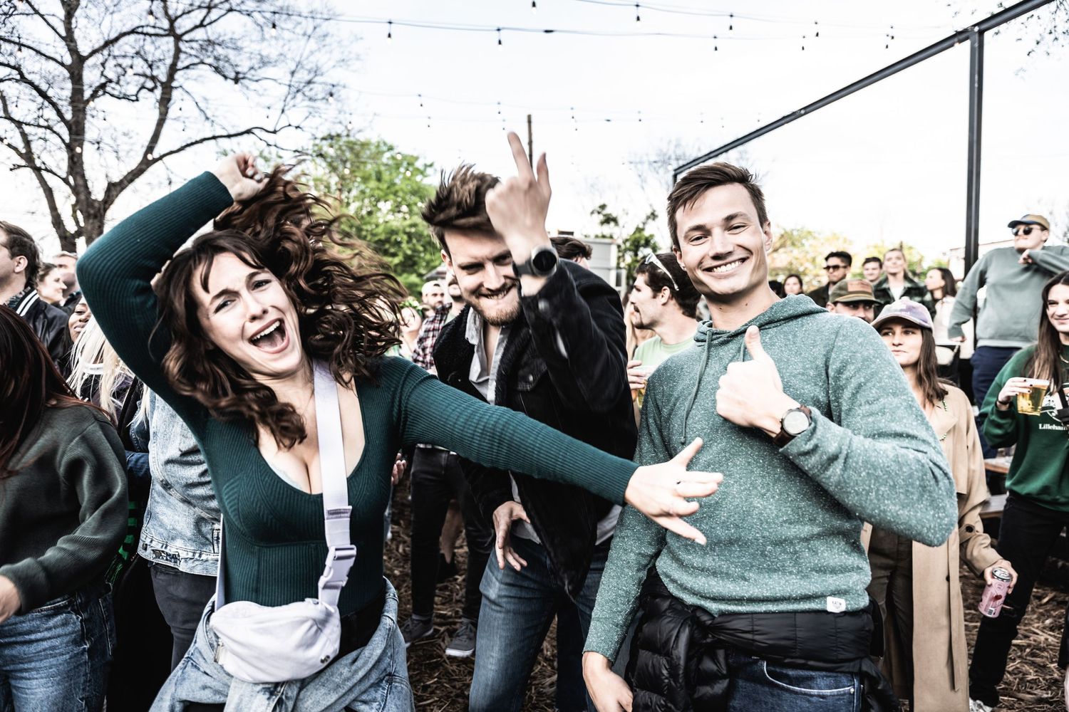 Concert attendees dancing and celebrating at outdoor music festival.