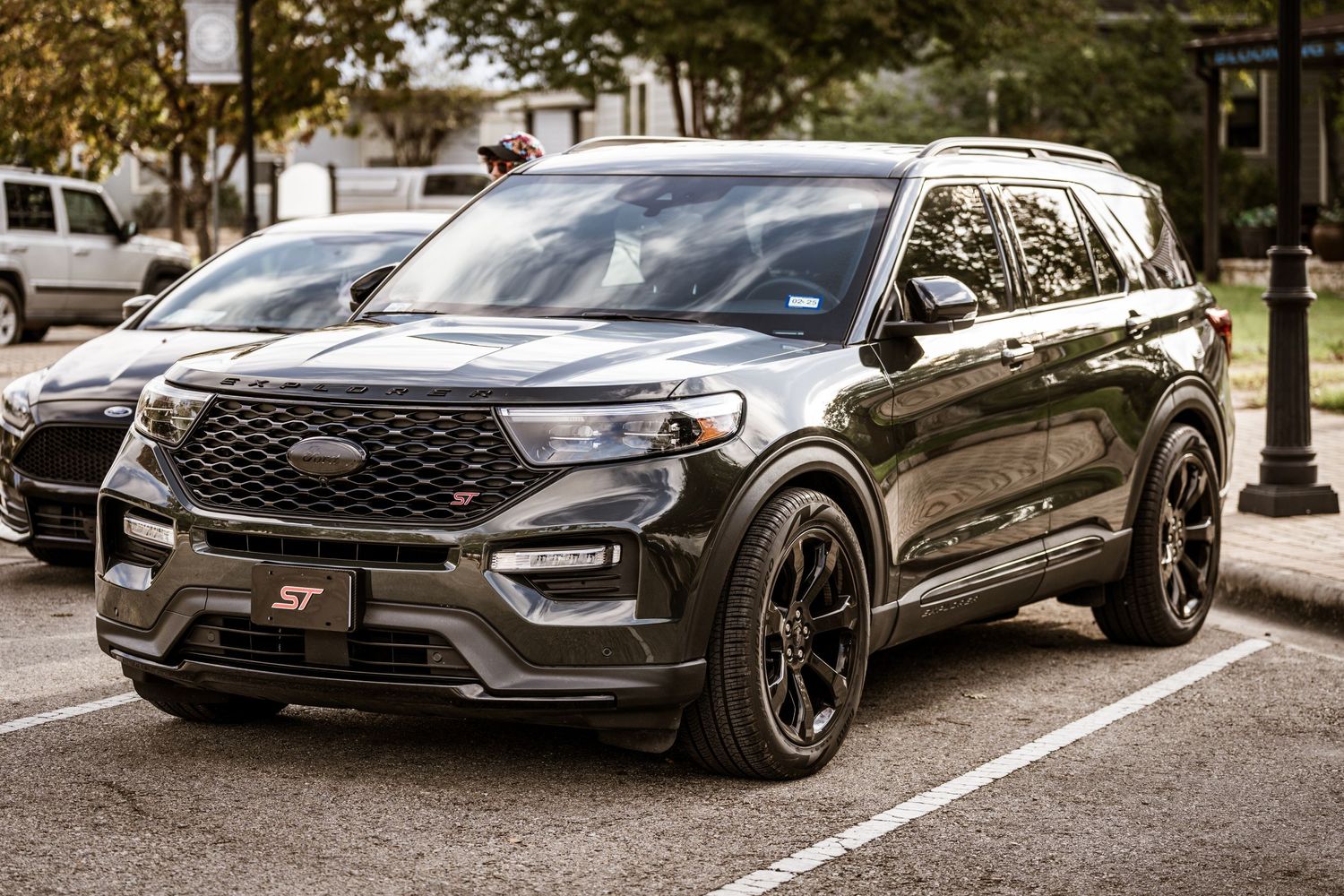 Black Ford Explorer ST with custom wheels parked in urban setting.