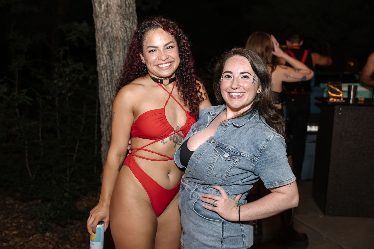 Two people posing outdoors at night during an event.