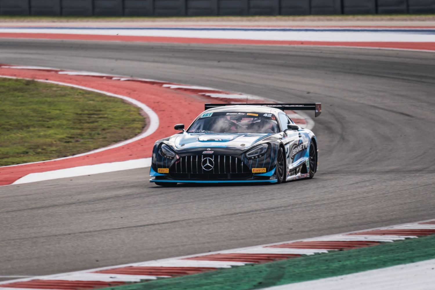 Mercedes-AMG GT3 race car taking a corner on a professional racing track.