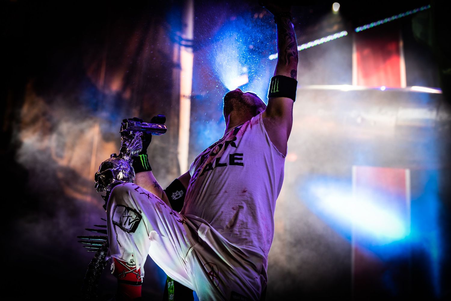 DJ performs at nightclub with colorful blue and purple lighting effects creating an atmospheric ambiance.