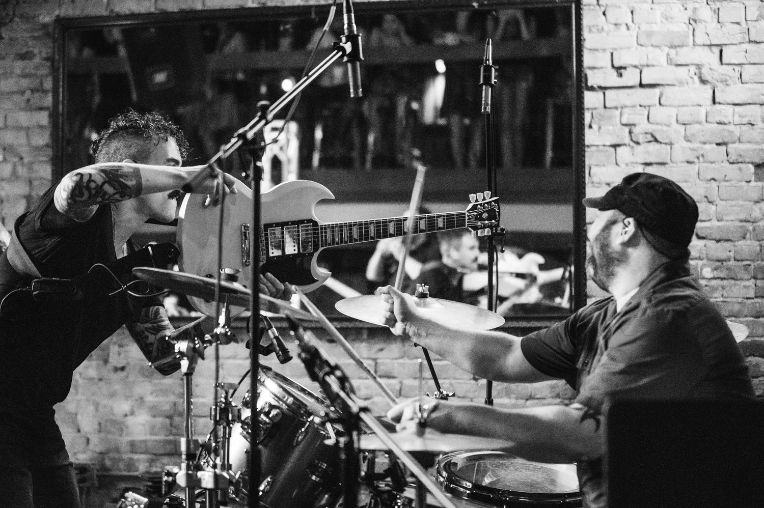 A series of black and white photos showing drummers performing with drum kits in various settings.